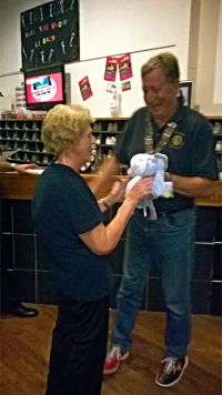 Lion Marjorie Cane being presented with the Booby prize by Lion President Alan Benson